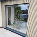 Silver Birch slatted cladding around glazed doors, with a Christmas tree inside