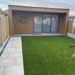 Garden room finished in composite cladding beside a lawn